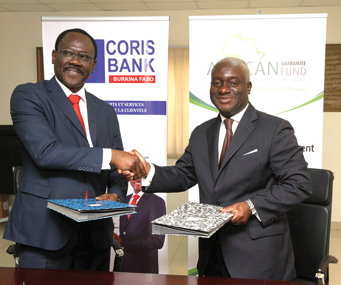 Emmanuel Sawadogo, Directeur Général de Coris Holding (en lunettes), et Félix Bikpo, le CEO d’AGF, ont signé les documents marquant le début de ce partenariat. (Ph.: Coris Bank)